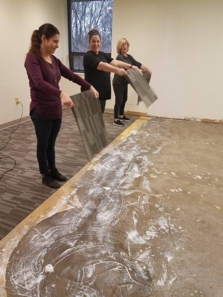 Ladies of TeamPAR work on flooring project